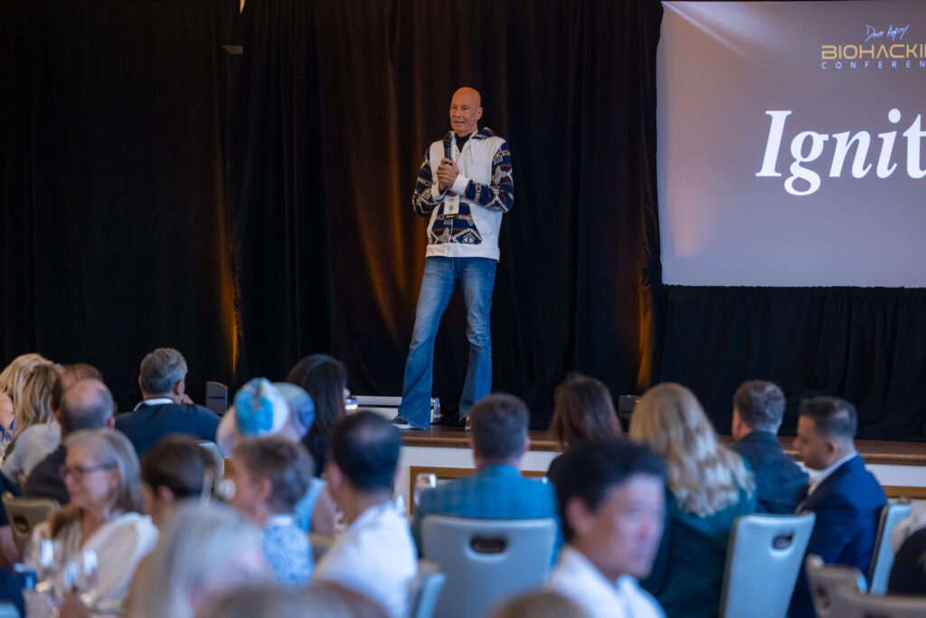 A speaker working a room. People engaged, taking notes, leaning in.