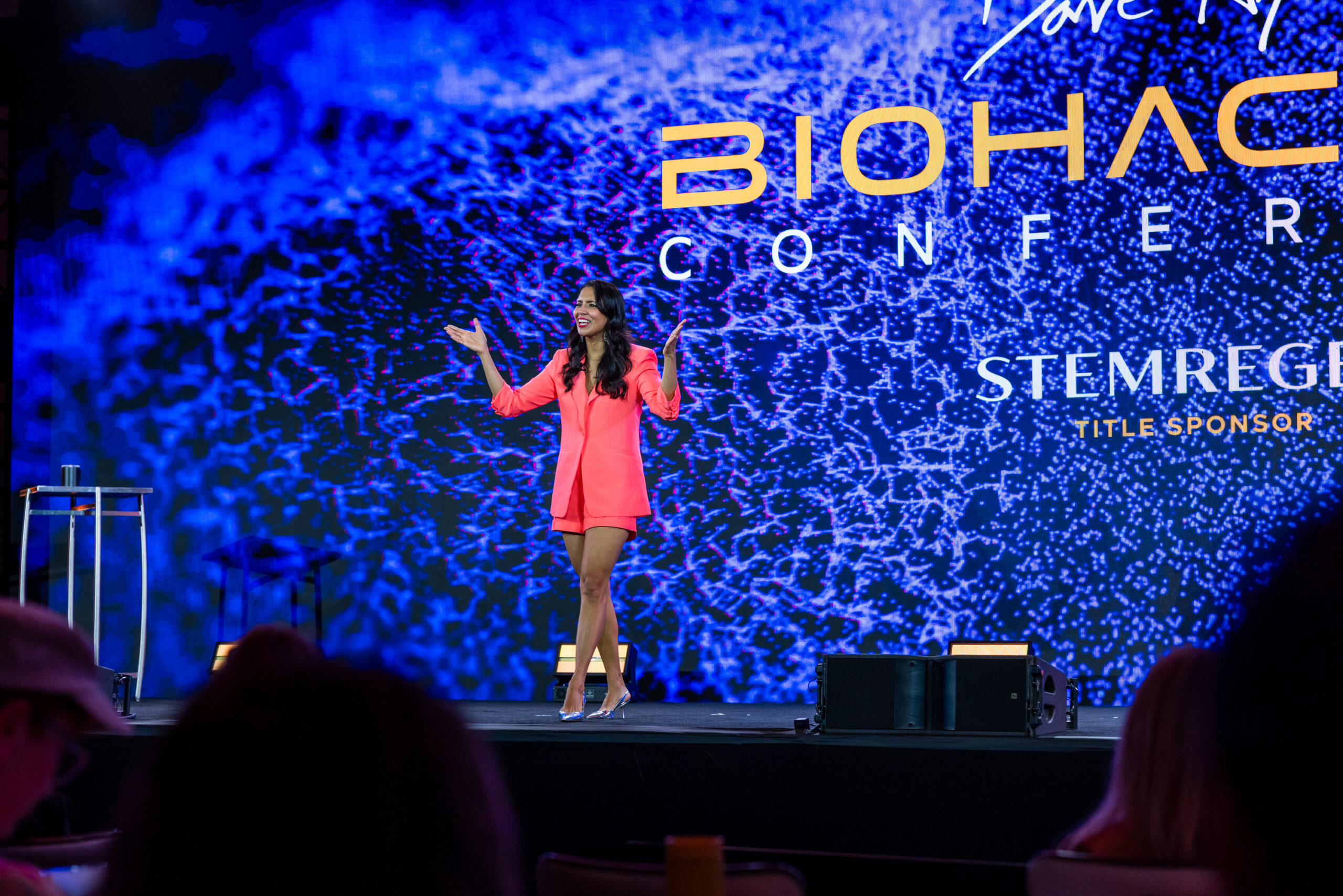 A woman speaking on stage to a large, engaged audience. Ideally from a previous Beyond event.