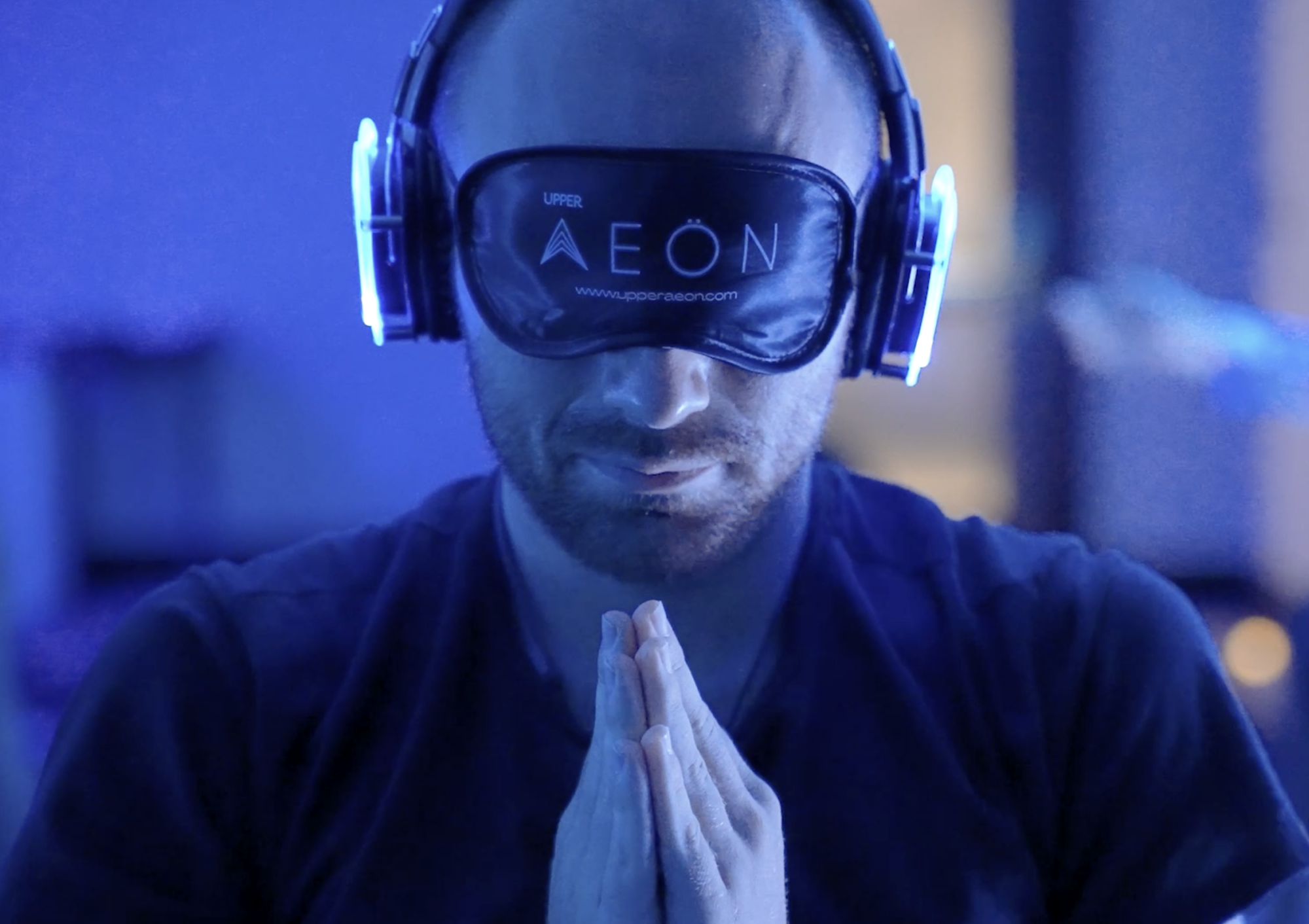 man meditating with eye mask and headphones